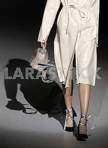 Model with a bag in his hand and the shadow of her dress during a demonstration of Ukrainian designer  Katerina KVIT