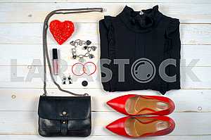 Women clothing set and accessories on white wooden background.