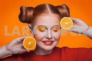 Young beautiful fashion model with orange. studio shot.