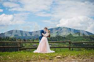 Romantic fairytale couple newlyweds kissing and embracing on a background of mountains. wedding walk on nature, Newlyweds outdoors portrait, soft light, series