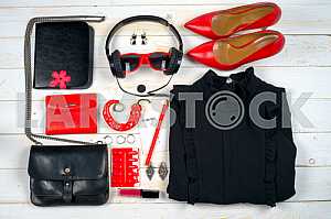 Women clothing set and accessories on white wooden background.