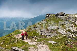 Two tourists with backpacks, go mountain ridge Chornohora