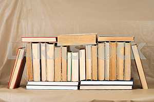Old and used hardback books or text books on wooden table. Books and reading are essential for self improvement, gaining knowledge and success in our careers, business and personal lives. Copy space