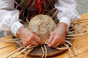 A woman weaves a hat made of straw on the Jagiellonian Fair