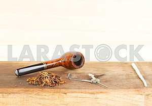 Smoking pipe on a wooden table. Aroma. Copy space