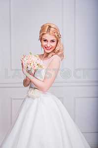 Blonde beautiful bride in short dress with wedding bouquet