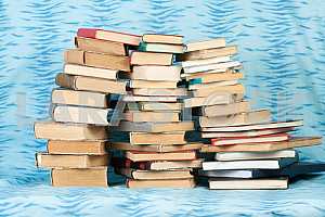 Old and used hardback books or text books on wooden table. Books and reading are essential for self improvement, gaining knowledge and success in our careers, business and personal lives. Copy space
