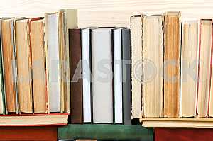 Открытая книга, стопка книг в твердом переплете на деревянном столе. Обратно в школу. Копирование пространства