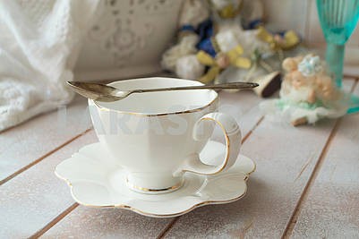 Closeup of white cup of tea on vintage wooden background.