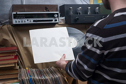 Retro styled image of a collection of old vinyl record lp's with sleeves on a wooden background. Copy space