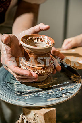 The potter gives the child to his pitcher made on potter's wheel