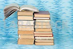 Old and used hardback books or text books on wooden table. Books and reading are essential for self improvement, gaining knowledge and success in our careers, business and personal lives. Copy space