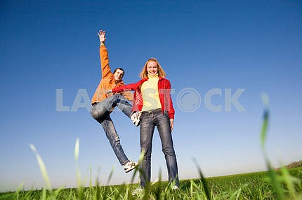 Happy smiling couple  jumping in blue sky