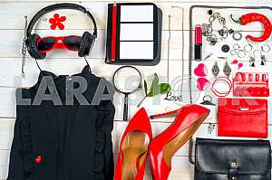 Women clothing set and accessories on white wooden background.