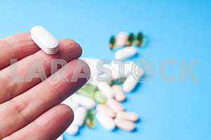 Many pills and tablets isolated on light blue background