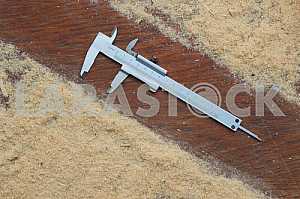 Different construction tools on a wooden background - screwdriver, caliper.