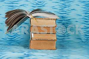 Old and used hardback books or text books on wooden table. Books and reading are essential for self improvement, gaining knowledge and success in our careers, business and personal lives. Copy space