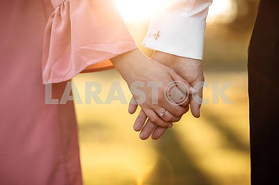 young couple holding hands on the arm ring. Close Up view