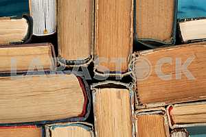 Old and used hardback books or text books on wooden table. Books and reading are essential for self improvement, gaining knowledge and success in our careers, business and personal lives. Copy space