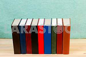 Open book, stack of hardback books on wooden table. Back to school. Copy space
