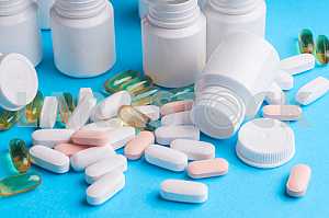 Many pills and tablets isolated on light blue background