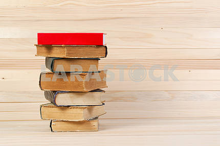 Stack of hardback books on wooden table. Back to school.