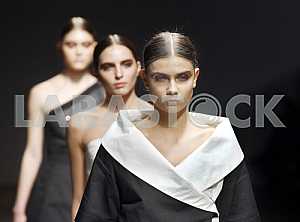 Models in black and white clothes show a collection by Ukrainian designer Ekaterina Sadovskaya