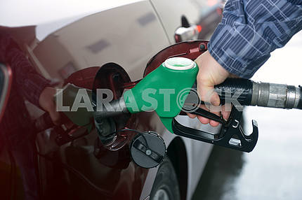 man hand refilling up gas tank of the car