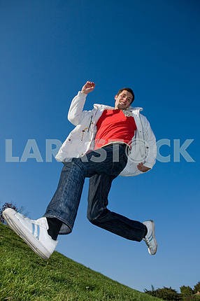 Happy young man - jumping in blue sky