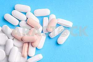 Many pills and tablets isolated on light blue background