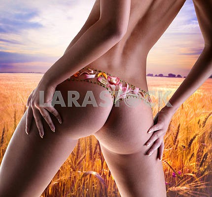 Girl with a flower underwear. Golden wheat ready for harvest gro