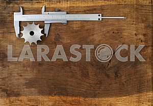 Different construction tools on a wooden background - screwdriver, caliper.