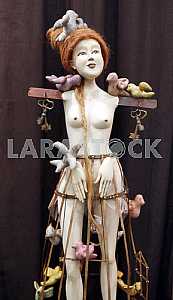 Doll of girl with birds on the bench