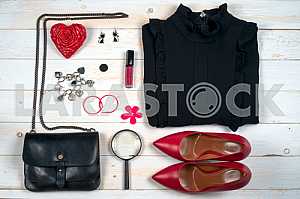 Women clothing set and accessories on white wooden background.