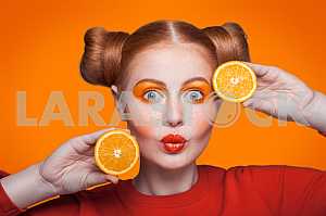 Young beautiful fashion model with orange. studio shot.