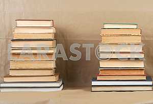 Old and used hardback books or text books on wooden table. Books and reading are essential for self improvement, gaining knowledge and success in our careers, business and personal lives. Copy space