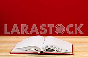 Открытая книга, стопка книг в твердом переплете на деревянном столе. Обратно в школу. Копирование пространства