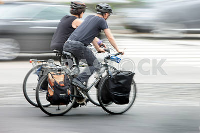 People on bicycles in motion blur on a city roadway