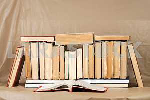 Old and used hardback books or text books on wooden table. Books and reading are essential for self improvement, gaining knowledge and success in our careers, business and personal lives. Copy space