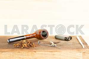 Smoking pipe on a wooden table. Aroma. Copy space