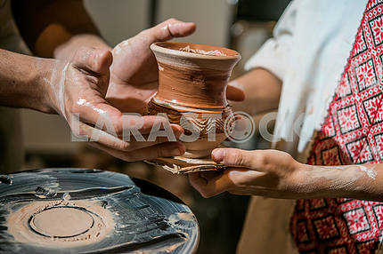 The potter gives the child to his pitcher made on potter's wheel