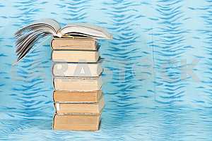Old and used hardback books or text books on wooden table. Books and reading are essential for self improvement, gaining knowledge and success in our careers, business and personal lives. Copy space