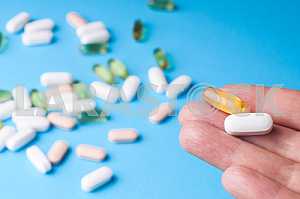 Many pills and tablets isolated on light blue background