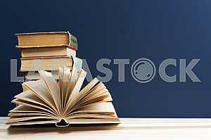 Стек книг в твердом переплете на синей ткани. Обратно в школу. Копирование пространства