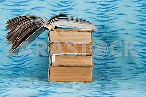 Old and used hardback books or text books on wooden table. Books and reading are essential for self improvement, gaining knowledge and success in our careers, business and personal lives. Copy space
