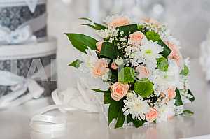 Wedding bouquet made of roses, chrysanthemum and laying on the white box