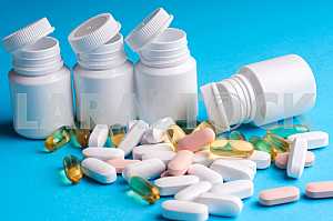 Many pills and tablets isolated on light blue background