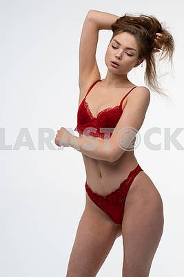 Young beautiful girl pose in studio in red lingerie