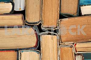 Old and used hardback books or text books on wooden table. Books and reading are essential for self improvement, gaining knowledge and success in our careers, business and personal lives. Copy space
