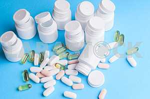 Many pills and tablets isolated on light blue background